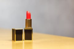 Rossetto rosso con la copertura aperta, la forma rettangolare, il nero ed il tubo di lusso dell'oro, sistemato sulla tavola di le fotografia stock Rossetto rosso con la copertura aperta, la forma rettangolare, il nero ed il tubo di lusso dell'oro, sistemato sulla tavola di le fotografia stock