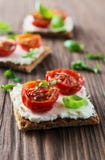 Rostade bröd (Crostini) med ricotta och körsbärsröda tomater Arkivfoton Rostade bröd (Crostini) med ricotta och körsbärsröda tomater Arkivfoton