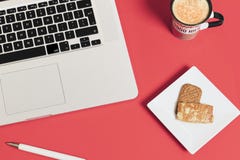 Rote Farbe des modernen Geschäfts-Hintergrundes mit Kaffeetasse, Laptopnotizbuch, Stift und Plätzchen lizenzfreie stockfotos Rote Farbe des modernen Geschäfts-Hintergrundes mit Kaffeetasse, Laptopnotizbuch, Stift und Plätzchen lizenzfreie stockfotos