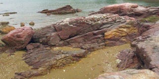 Rote und gelbe Sandsteine auf Strand lizenzfreie stockfotos Rote und gelbe Sandsteine auf Strand lizenzfreie stockfotos