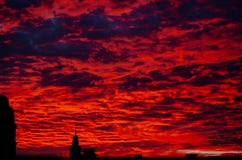 Roter blutiger Sonnenuntergang im bewölkten Himmel über dem Dorf Schöne Landschaftlandschaft lizenzfreies stockbild Roter blutiger Sonnenuntergang im bewölkten Himmel über dem Dorf Schöne Landschaftlandschaft lizenzfreies stockbild