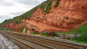 Roter Felsen und Eisenbahn in Dawlish Warren, Devon stockbild Roter Felsen und Eisenbahn in Dawlish Warren, Devon stockbild