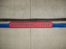 Rotes verschalendes Zonenzeichen auf Betonmauer in der U-Bahnstation lizenzfreie stockbilder Rotes verschalendes Zonenzeichen auf Betonmauer in der U-Bahnstation lizenzfreie stockbilder