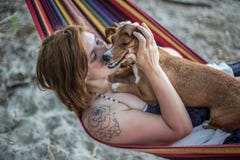 Rothaarigemädchen und ihr Hund, die auf einem Aufenthaltsraum am Strand im Sommer liegen stockfotografie Rothaarigemädchen und ihr Hund, die auf einem Aufenthaltsraum am Strand im Sommer liegen stockfotografie