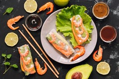 Rotoli di molla vietnamiti con i gamberetti, avocado, lattuga, salse, bastoncini Fondo concreto nero, primo piano di vista superi immagini stock libere da diritti Rotoli di molla vietnamiti con i gamberetti, avocado, lattuga, salse, bastoncini Fondo concreto nero, primo piano di vista superi immagini stock libere da diritti