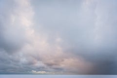 Rotsen met sneeuw worden behandeld die Donkere wolken en bevroren Oostzee stock afbeeldingen Rotsen met sneeuw worden behandeld die Donkere wolken en bevroren Oostzee stock afbeeldingen