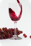 Rotwein goss in ein Weinglas mit frischen Trauben als Hintergrund foto lizenzfreie stockfotos Rotwein goss in ein Weinglas mit frischen Trauben als Hintergrund foto lizenzfreie stockfotos