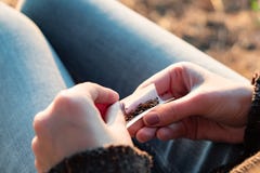 Roulement d'une cigarette de tabac Image haute étroite de maki femelle de mains photo stock Roulement d'une cigarette de tabac Image haute étroite de maki femelle de mains photo stock