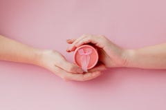 Round pink gift box in women`s hands on a pink background. Festive concept for Valentine`s day, Mother`s day or birthday stock photography Round pink gift box in women`s hands on a pink background. Festive concept for Valentine`s day, Mother`s day or birthday stock photography