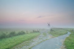 Route au moulin à vent néerlandais en brouillard de matin Images libres de droits Route au moulin à vent néerlandais en brouillard de matin Images libres de droits