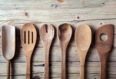 Row of assorted old wooden kitchen utensils