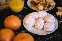 Roze heemst op een plaat en sinaasappelen die op een houten lijst liggen royalty-vrije stock afbeelding Roze heemst op een plaat en sinaasappelen die op een houten lijst liggen royalty-vrije stock afbeelding