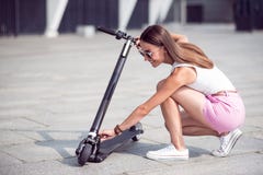 Rozochocona kobieta używa kopnięcie hulajnoga fotografia stock Rozochocona kobieta używa kopnięcie hulajnoga fotografia stock