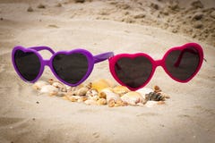 Rozsypisko skorupy i okulary przeciwsłoneczni na piasku przy plażą Obrazy Royalty Free Rozsypisko skorupy i okulary przeciwsłoneczni na piasku przy plażą Obrazy Royalty Free