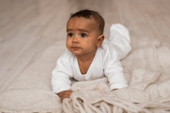 Rozważna biracial mieszanka latynosa i amerykanina afrykańskiego pochodzenia niemowlaka lying on the beach zdjęcie stock Rozważna biracial mieszanka latynosa i amerykanina afrykańskiego pochodzenia niemowlaka lying on the beach zdjęcie stock