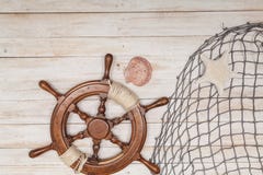 Rudder of sailing ship, fishing net with sea shells on wooden background Stock Image Rudder of sailing ship, fishing net with sea shells on wooden background Stock Image