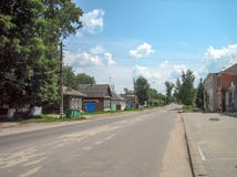 Rue directe d'asphalte le long du village avec un-et des maisons de deux étages photographie stock libre de droits Rue directe d'asphalte le long du village avec un-et des maisons de deux étages photographie stock libre de droits