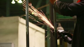 Rueda eléctrica que muele en la estructura de acero en fábrica almacen de metraje de vídeo Rueda eléctrica que muele en la estructura de acero en fábrica almacen de metraje de vídeo