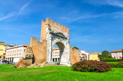Ruinen der alten Backsteinmauer und des Steintor Bogens von Augustus Arco di Augusto, gr?ner Rasen mit Busch von Blumen in Rimini lizenzfreie stockfotos Ruinen der alten Backsteinmauer und des Steintor Bogens von Augustus Arco di Augusto, gr?ner Rasen mit Busch von Blumen in Rimini lizenzfreie stockfotos