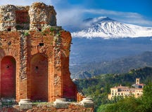 Ruins of ancient Greek theater in Taormina and Etna volcano in the background