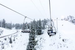 Ruka, Finland - November 24, 2012: Skiers are sitting on the chair ski lift at Ruka ski resort in freezing day royalty free stock images Ruka, Finland - November 24, 2012: Skiers are sitting on the chair ski lift at Ruka ski resort in freezing day royalty free stock images