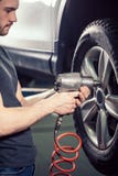 Rullar den ändrande bilen för mekanikern in garaget för den auto reparationen arkivfoto Rullar den ändrande bilen för mekanikern in garaget för den auto reparationen arkivfoto