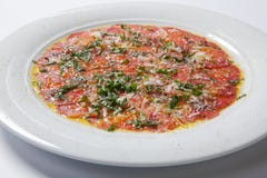 Rundvleescarpaccio met ruccola op een witte plaat wordt gediend die royalty-vrije stock afbeeldingen Rundvleescarpaccio met ruccola op een witte plaat wordt gediend die royalty-vrije stock afbeeldingen