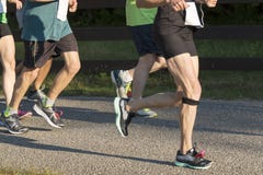 Runers som springer ett 5000 meter lopp i solsken Fotografering för Bildbyråer