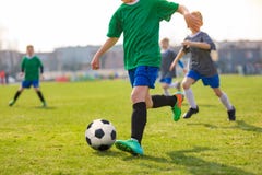 Running Children Football Players. Kids Playing Soccer Match. Football Players Duel on Grass Pitch royalty free stock image Running Children Football Players. Kids Playing Soccer Match. Football Players Duel on Grass Pitch royalty free stock image