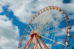 Ruota di osservazione sul cielo blu con le nuvole bianche al giorno di estate soleggiato immagini stock Ruota di osservazione sul cielo blu con le nuvole bianche al giorno di estate soleggiato immagini stock