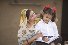 Rural mother helping daughter with her homework stock photo Rural mother helping daughter with her homework stock photo