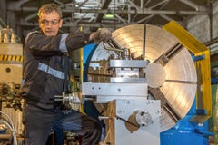 2019 01 16: Russland, Ryazan Mann, der großen industriellen CNC-Drehbankmaschinenausschnitt die Stahlstange justiert stockfotografie 2019 01 16: Russland, Ryazan Mann, der großen industriellen CNC-Drehbankmaschinenausschnitt die Stahlstange justiert stockfotografie