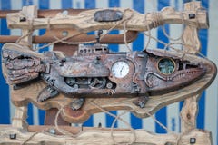 Rusty iron fish in a wooden frame wrapped with a rope, with a clock in the middle, white and blue background royalty free stock photography Rusty iron fish in a wooden frame wrapped with a rope, with a clock in the middle, white and blue background royalty free stock photography