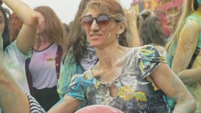 RYSSLAND IRKUTSK - JUNI 27, 2018: Lyckliga ungdomarsom dansar och firar under den Holi festivalen av färger Folkmassa av RYSSLAND IRKUTSK - JUNI 27, 2018: Lyckliga ungdomarsom dansar och firar under den Holi festivalen av färger Folkmassa av