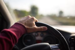 Räcka hållande på det svarta styrninghjulet, medan köra i bilen arkivbild Räcka hållande på det svarta styrninghjulet, medan köra i bilen arkivbild