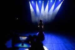 Ręki z smartphone nagrywają muzyka na żywo festiwal i brać wewnątrz fotografia koncertowej sceny luksusu żywy koncertowy przyjęci zdjęcia stock Ręki z smartphone nagrywają muzyka na żywo festiwal i brać wewnątrz fotografia koncertowej sceny luksusu żywy koncertowy przyjęci zdjęcia stock