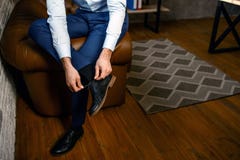 Rżnięty widok młody przystojny biznesmen w jego swój biurze Trzyma nogę na inny jeden i wiąże koronki na butach ruchliwie zdjęcie royalty free Rżnięty widok młody przystojny biznesmen w jego swój biurze Trzyma nogę na inny jeden i wiąże koronki na butach ruchliwie zdjęcie royalty free