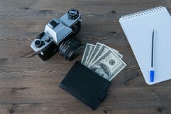 Rétro appareil-photo, bourse et bloc-notes avec le stylo sur une table en bois photo libre de droits Rétro appareil-photo, bourse et bloc-notes avec le stylo sur une table en bois photo libre de droits