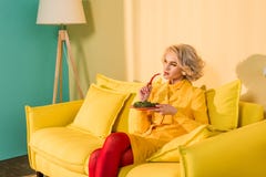 rétro femme dénommée avec le brocoli sur le poivre de plat et de piment à disposition se reposant sur le sofa à l'appartement lum photographie stock rétro femme dénommée avec le brocoli sur le poivre de plat et de piment à disposition se reposant sur le sofa à l'appartement lum photographie stock