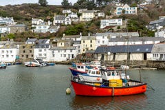 Röd fiskebåt som förtöjas i den historiska och pittoreska Polperro hamnen i Cornwall, UK royaltyfria foton Röd fiskebåt som förtöjas i den historiska och pittoreska Polperro hamnen i Cornwall, UK royaltyfria foton