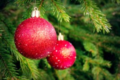 Röda bollar på granen, del av julgranen med julpynt arkivfoton Röda bollar på granen, del av julgranen med julpynt arkivfoton