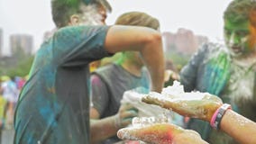 RÚSSIA, IRKUTSK - 27 DE JUNHO DE 2018: Jovens felizes que dançam e que comemoram durante o festival de Holi das cores Multidão de RÚSSIA, IRKUTSK - 27 DE JUNHO DE 2018: Jovens felizes que dançam e que comemoram durante o festival de Holi das cores Multidão de
