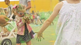 RÚSSIA, IRKUTSK - 27 DE JUNHO DE 2018: Jovens felizes que dançam e que comemoram durante o festival de Holi das cores Multidão de RÚSSIA, IRKUTSK - 27 DE JUNHO DE 2018: Jovens felizes que dançam e que comemoram durante o festival de Holi das cores Multidão de