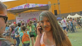RÚSSIA, IRKUTSK - 27 DE JUNHO DE 2018: Jovens felizes que dançam e que comemoram durante o festival de Holi das cores Multidão de RÚSSIA, IRKUTSK - 27 DE JUNHO DE 2018: Jovens felizes que dançam e que comemoram durante o festival de Holi das cores Multidão de