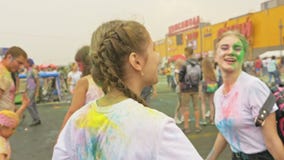 RÚSSIA, IRKUTSK - 27 DE JUNHO DE 2018: Jovens felizes que dançam e que comemoram durante o festival de Holi das cores Multidão de RÚSSIA, IRKUTSK - 27 DE JUNHO DE 2018: Jovens felizes que dançam e que comemoram durante o festival de Holi das cores Multidão de