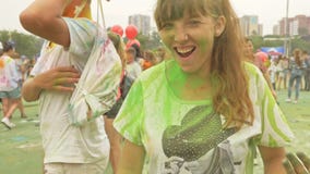 RÚSSIA, IRKUTSK - 27 DE JUNHO DE 2018: Jovens felizes que dançam e que comemoram durante o festival de Holi das cores Multidão de RÚSSIA, IRKUTSK - 27 DE JUNHO DE 2018: Jovens felizes que dançam e que comemoram durante o festival de Holi das cores Multidão de