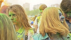 RÚSSIA, IRKUTSK - 27 DE JUNHO DE 2018: Jovens felizes que dançam e que comemoram durante o festival de Holi das cores Multidão de RÚSSIA, IRKUTSK - 27 DE JUNHO DE 2018: Jovens felizes que dançam e que comemoram durante o festival de Holi das cores Multidão de