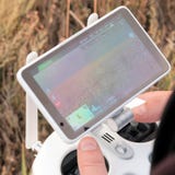 Ręki mężczyzna na joysticka pulpicie operatora bezpilotowy powietrzny pojazd Rolnik kontroluje trutni i widzii pole z a fotografia royalty free Ręki mężczyzna na joysticka pulpicie operatora bezpilotowy powietrzny pojazd Rolnik kontroluje trutni i widzii pole z a fotografia royalty free