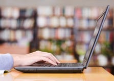Ręki pisać na maszynie na notatniku w bibliotece obrazy royalty free Ręki pisać na maszynie na notatniku w bibliotece obrazy royalty free