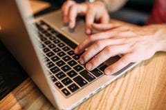 Ręki zamykają up palce pisać na maszynie na laptopie, mężczyzna w kawiarni obraz stock Ręki zamykają up palce pisać na maszynie na laptopie, mężczyzna w kawiarni obraz stock